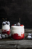 Raspberry mousse with yogurt and frozen cherries served in jars