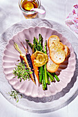 Colorful mini carrots and mini green asparagus with pistou