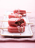 Vegan cakesicles covered in pink rice milk chocolate
