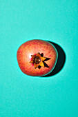 Pomegranate on turquoise background