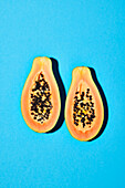 Halbierte Papaya auf blauem Untergrund