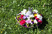 Flower bowl with Easter bunny figurine on grass