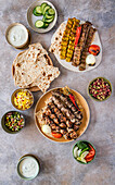 Kabab Koobideh (Iranian barbecue skewers) with salads, rice and tandoor bread