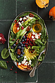 Spinach salad with persimmon, blueberries, pomegranate, goat cheese, and caramelized pecans