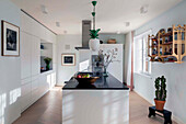 Elegant white kitchen, kitchen island with black granite worktop