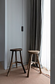 Changing room with built-in wardrobe, wooden stool in front of window