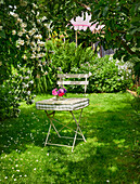 Gartenstuhl mit Kissen und Blumenvase