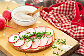 Slice of bread topped with butter, radishes and chives
