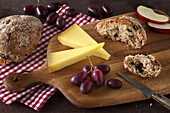 Apple-Vinschgerl with cheese and grapes on a board
