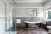 Freestanding bathtub in metallic look in a bathroom with wood-look floor tiles