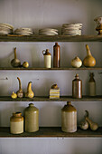 Wooden shelf with various earthenware pots and crockery