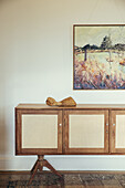 Sideboard with Viennese wickerwork, arm sculpture, painting above