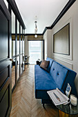 Blue sofa bed, large wardrobe with mirrored doors, desk in the background