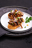Toasted baguette topped with pulled mushrooms, beech mushrooms and onions
