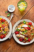Roasted chicken on couscous with peppers and tomatoes from the oven