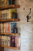 Wooden shelves with books against rustic brick wall
