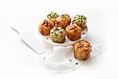 Three savory muffins with tomatoes, peas, and bacon
