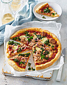 Hausgemachte Vollkornpizza mit Thunfisch, Spinat und roten Zwiebeln