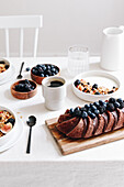 Breakfast table with yoghurt bowls, berries and chocolate cake