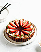 Nougat tart with sliced almonds and strawberries