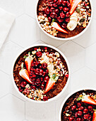 Chocolate porridge bowl with cherries, strawberries, granola and banana