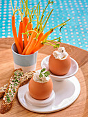 Boiled eggs with goat yogurt, buttered bread with chives and carrots