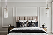 Opulentes Schlafzimmer in neutralen Tönen mit getäfelten Wänden und hängenden Kronleuchtern