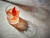 A blood orange drink with ice cubes