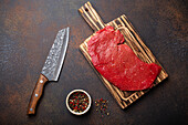 Raw beef steak on a wooden cutting board