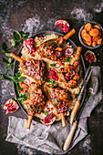 Lamb shanks on couscous with pomegranate, mint and dried apricots