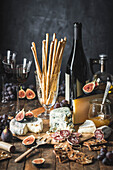 Cheese and sausage platter with fresh figs and crackers, served with red wine