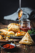 Filo pastry and goat cheese triangles with honey, chili, herb sauce