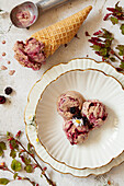 Chocolate blackberry ice cream in waffle cone and bowl