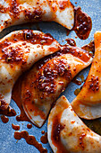 Filled dumplings topped with chili oil