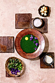 Nettle soup with quail yolk, violet blossoms, cream, croutons