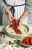 Making Italian focaccia with cherry tomatoes