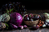 violet vegetables on the wooden background, purple artichoke, tomatoes, oniones, salad