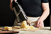 Hands grating cheese