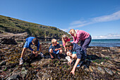 Children and adult exploring the foreshore