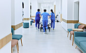 Wheeling patient bed through hospital corridor