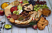 Appetizer board with crackers, cheese, vegetables, and grapes