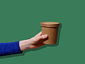 Take Out container for soup against a green background