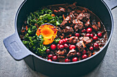 Wild game stew with cranberries, kale, and peach