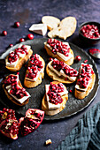 Crostini with brie, cranberry chutney, and pomegranate seeds