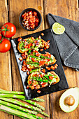 Bruschetta with green asparagus, avocado, and tomatoes