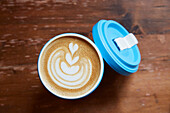 Cappuccino mit Latte-Art in To-go Becher