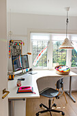 Home study with desk, computer and colourful wall decoration