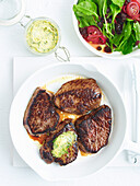 Grilled steaks with caper butter and rocket salad