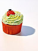 Cupcake with green frosting and marzipan ladybirds