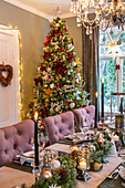 Festlich gedeckter Esstisch mit Weihnachtsbaum und Kronleuchter